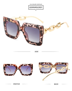 Detail of square leopard print sunglasses featuring thick gold chain temples and gradient lenses