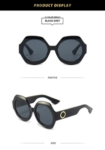 Vue détaillée de lunettes de soleil géométriques noires avec détails en anneau doré