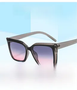 Détail de lunettes de soleil carrées bicolores avec verres dégradés bleu et rose