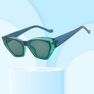 Fashionable two-tone cat eye sunglasses with translucent green frame on blue background