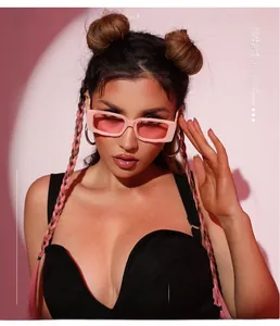 Close-up of pink square sunglasses with thick matte frames worn by a fashion model