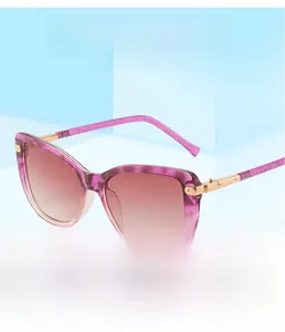 Close-up of stylish pink cat-eye sunglasses with gold metal hinges and gradient lenses