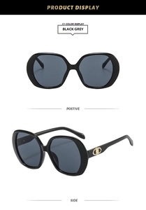 Detail of black sunglasses featuring golden chain linkage logo on the temples