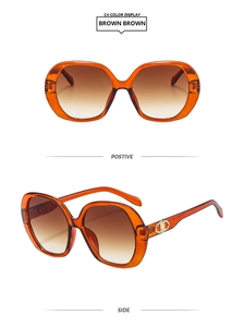 Detail of oversized brown gradient sunglasses with gold Triomphe metal buckle and frame