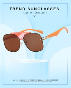 Detail of orange aviator sunglasses featuring UV400 lenses and unique hollow metal hinges