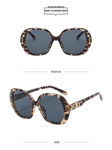 Detail view of large retro sunglasses with tortoiseshell frames and golden temple accents