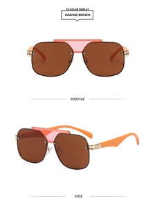 Detail view of orange brown oversized pilot sunglasses with gold metal hinges and frame