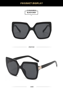 Detail of black square cat-eye sunglasses with rhinestone hinges and grey lenses