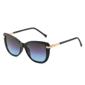 Women's cat eye sunglasses with black frames, blue gradient lenses, and gold metal accents