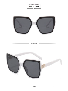 Macro detail of white and black square cat eye sunglasses with rhinestone temples