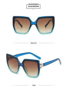 Close-up of oversized square sunglasses with blue-green gradient frame and rhinestone hinges