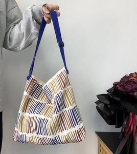 Detailed shot of vertical striped canvas bag with adjustable wide fabric shoulder strap