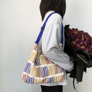 Detail of colorful striped canvas tote bag with adjustable wide blue shoulder strap