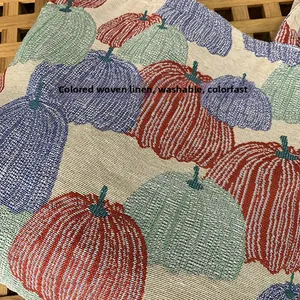 Close-up of woven pumpkin embroidery fabric showing texture and washable quality