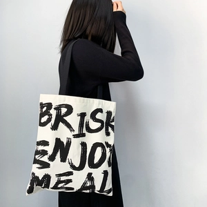 Detail of canvas tote bag showing black Brisk Enjoy Meal lettering and durable texture