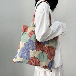 Detailed close-up of intricate pumpkin jacquard embroidery on woven shoulder tote bag