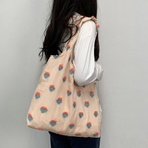 Detail showing oversized canvas tote with 3D tulip floral embroidery and soft pink mesh fabric