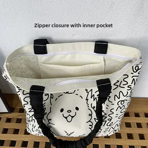 Detail showing the zipper closure and internal pocket of the white canvas tote bag