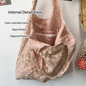 Pink canvas tote bag with daisy lace embroidery showing interior zipper pocket and lining