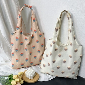 Detailed close-up of lazy-style canvas tote bags with 3D tulip floral embroidery