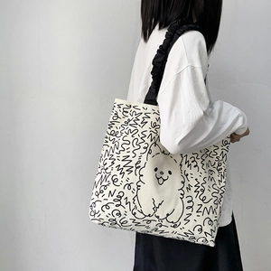 Detail of canvas tote bag with cartoon dog print and stylish black ruched shoulder strap