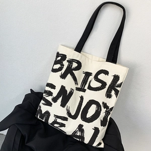 Close-up of durable canvas tote bag with black BRISK ENJOY MEAL printed text detail