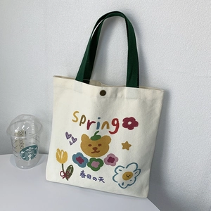 Dettaglio della borsa tote in tela color crema con stampa orsetto e chiusura in metallo