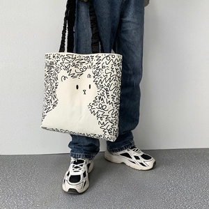 Detail of artistic cat and dog doodle print on white canvas tote bag with black pleated straps