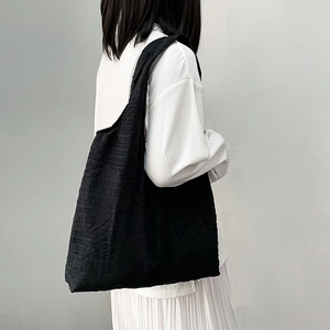 Detail of black textured canvas tote bag showing lightweight fabric and large capacity