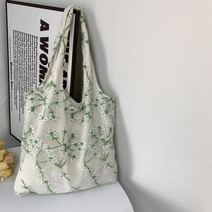 Detail of floral embroidery on double-layer lace mesh tote bag with a long handle
