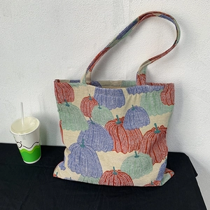 Detailed view of canvas tote bag featuring vintage pumpkin embroidery patterns