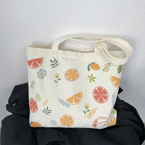 Detailed view of the fruit print canvas tote bag with a woven happiness label