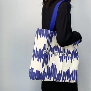 Dettaglio borsa tote in tela con stampa astratta blu e testo Pink Sunday sulla tracolla