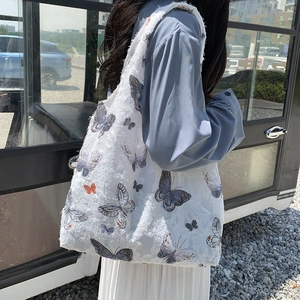 Detailed texture of white canvas tote bag with colorful butterfly prints and frayed edges