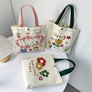 Dettaglio di borse in tela con stampe cartoon e chiusure in metallo su tavolo bianco