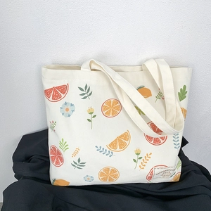 Close-up of fruit print and woven label on a cream white canvas tote bag