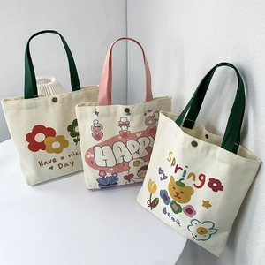Dettaglio di borse tote in tela con stampe floreali e resistenti bottoni a pressione