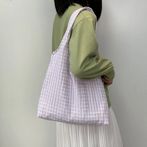 Close-up of light purple checkered tote bag with seersucker texture on shoulder