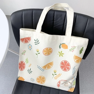 Detail of canvas tote bag with citrus fruit print and happiness slogan label