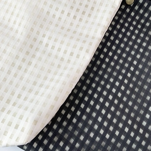 Detailed macro view of checkered canvas fabric textures and button closure for tote bag