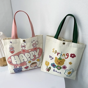 Dettaglio di borse in tela con graziose stampe cartoon e chiusura con bottone automatico