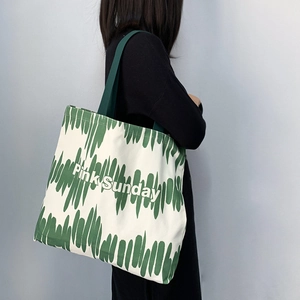 Borsa tote Pink Sunday in tela a strisce verdi indossata da una modella su sfondo grigio