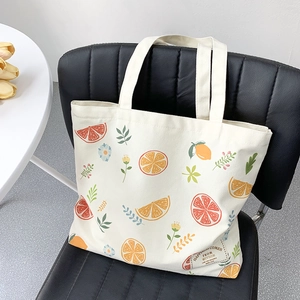 Detail of canvas tote bag featuring citrus prints and happiness decorative patch