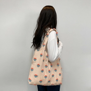 Close-up of floral embroidery on a pink canvas tote bag showing large capacity