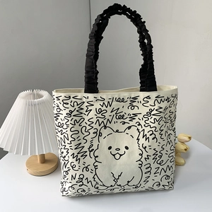 Detail of canvas tote bag with cartoon dog print and black pleated cloud handle strap