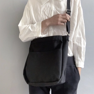 Minimalist black canvas crossbody bag with adjustable strap and large front pocket