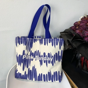 Dettaglio della borsa tote in tela con strisce blu e stampa Pink Sunday sulla sedia