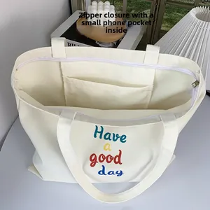 Detail view of large canvas tote bag with zipper closure and internal phone pocket