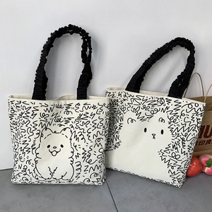 Detail of canvas tote bags with cute animal graffiti and black pleated handles