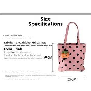 Pink polka dot canvas tote bag detail showing dimensions 35x39cm and plush charm